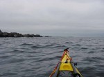 Day 143.1 Just passing the headland of Blodskytodden on a grey morning with Harbaken prominentary above the bow in the distance