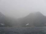Day 157.6 Another sleet shower in Oksfjorden with a shipwreck in the isolated cove